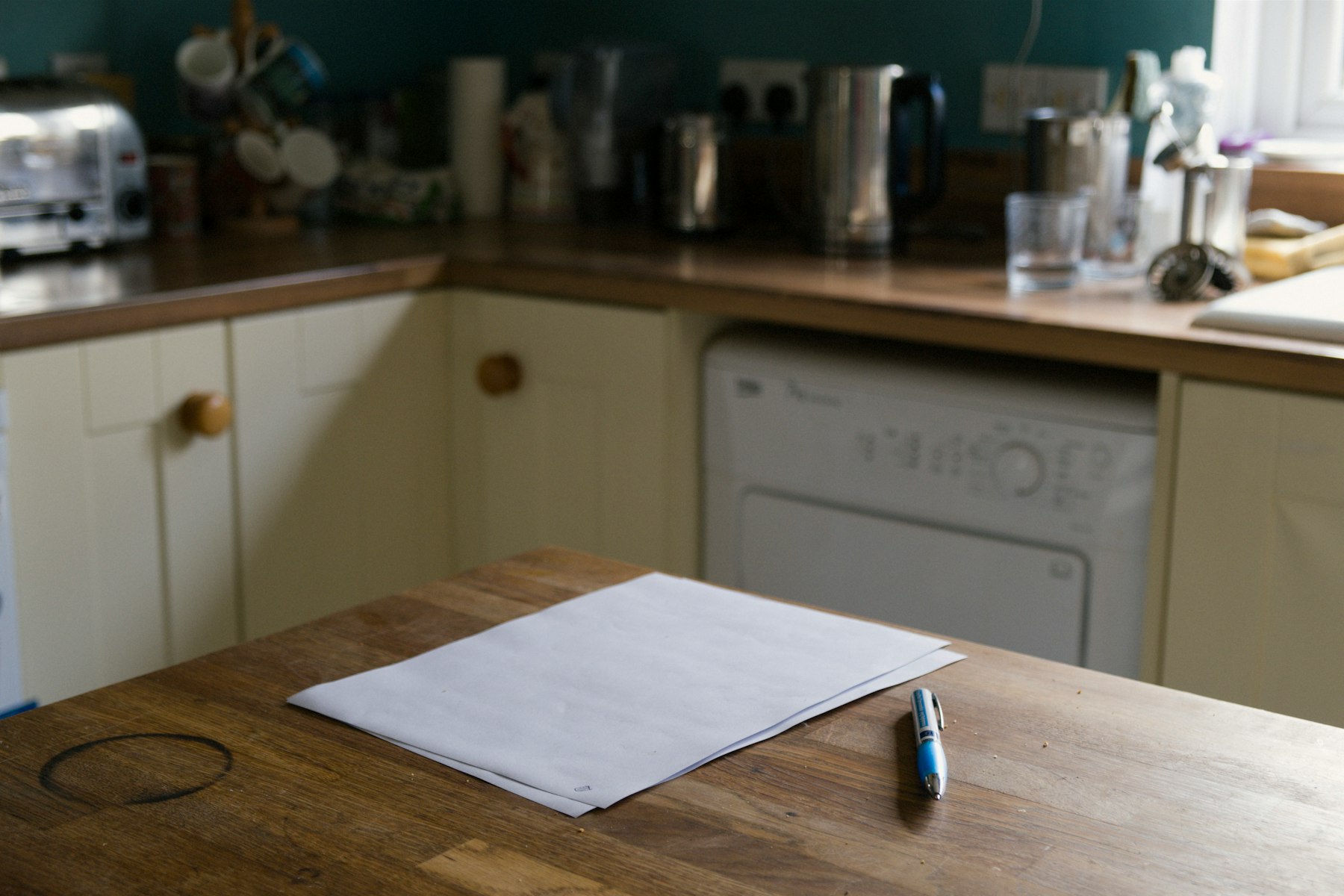 Papier et stylo posés sur une table de cuisine, au cœur d'une semaine chargée