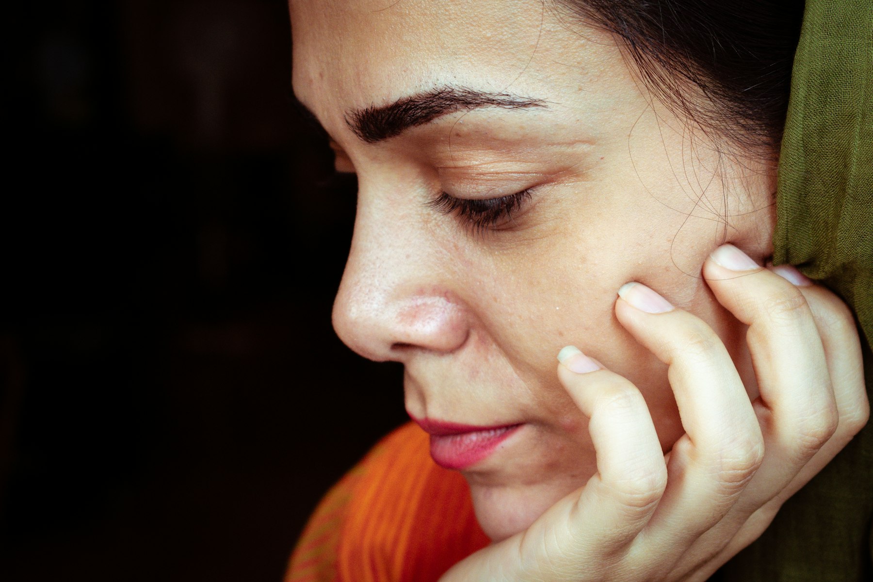 Profil d'une femme pensive dans une lumière douce, la mâchoire au repos