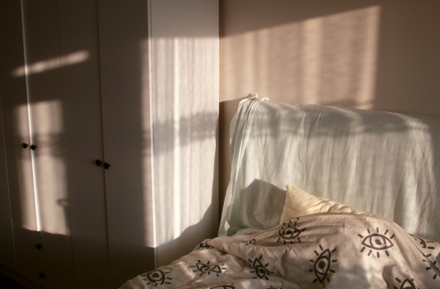 Lumière douce du matin entrant par la fenêtre et traversant le lit d'une chambre