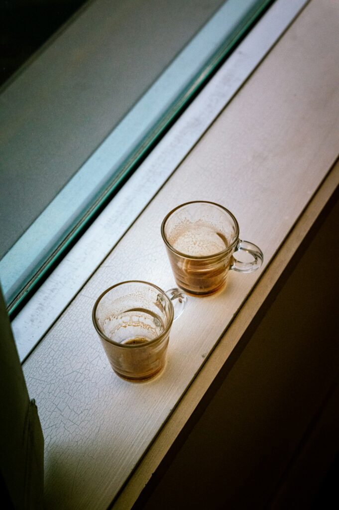 Deux tasses de café posées sur un rebord de fenêtre dans la lumière du jour